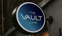 the vault cafe logo on the side of a building